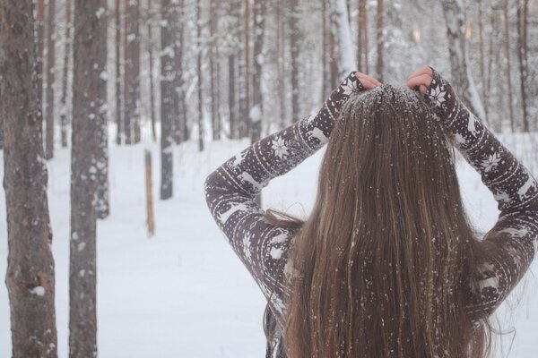 Charming girl under the snow in a snow-white forest