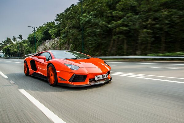 Lamborghini rosso che corre lungo la strada