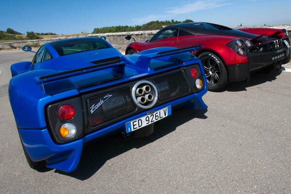 Вид сзади на два суперкара красного и синего цвета