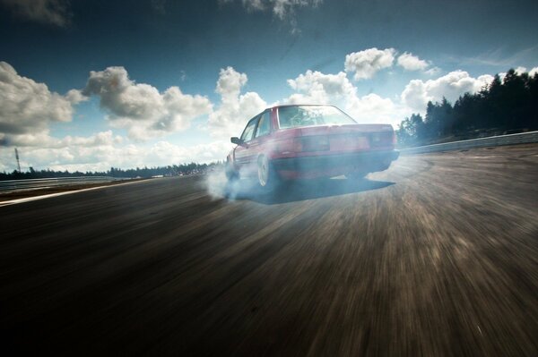 Bmw Drift en la carretera bajo el cielo nublado en una carretera vacía