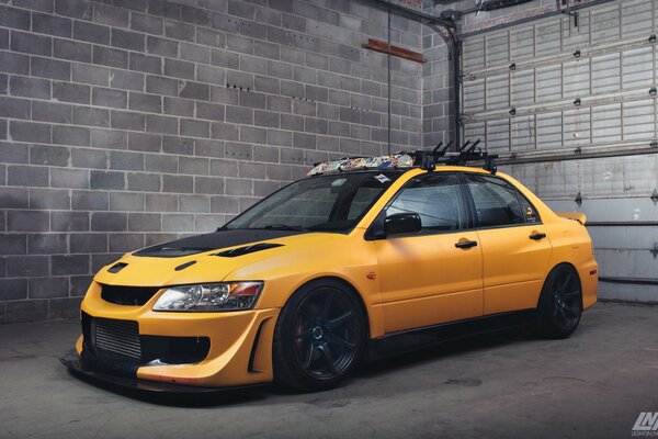Yellow Mitsubishi in a brick garage