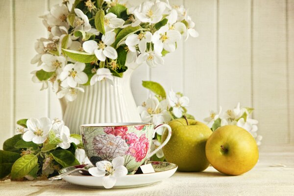 Flowers in a vase with a cup of tea