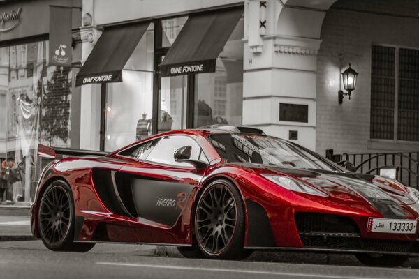 Auto rossa sullo sfondo di un edificio grigio