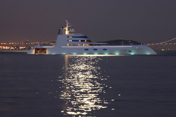 Yacht at sea on the background of the bridge and lights at night