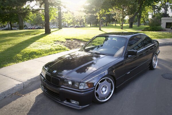 Negro tuneado BMW E36 bajo el sol