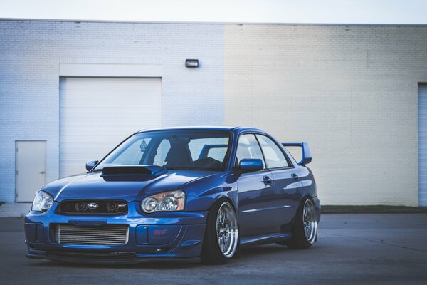Wallpaper with a blue subaru wrx at white garages