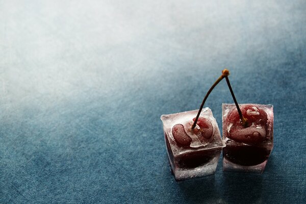 Cereza en el hielo sobre un fondo blanco y azul