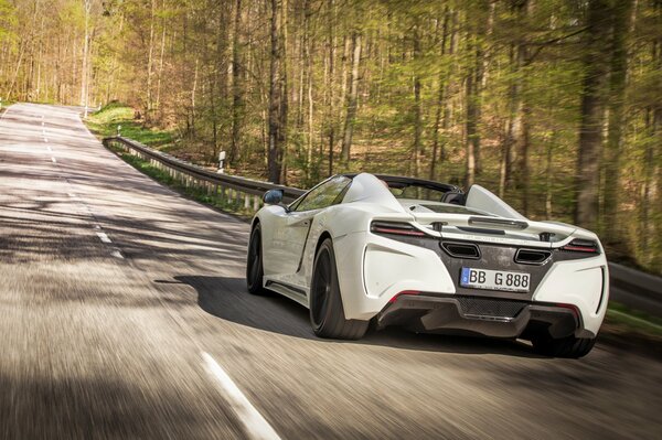 The gemballa car is driving along the road near the forest