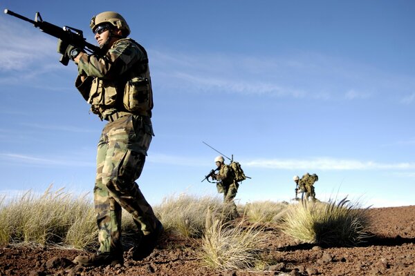 Soodaten in der Wüste mit Waffen