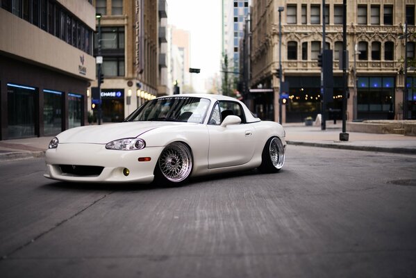 White mazda miata on the background of a city street