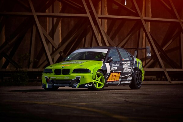 Une BMW E46 M3 de couleur verte dérive sportive sur la piste aem