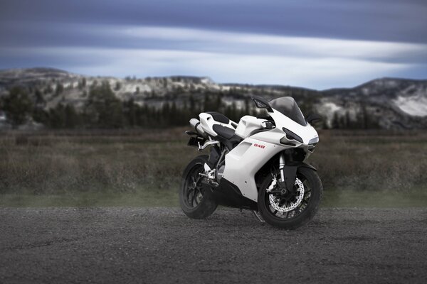 Photo of ducatti against the background of mountains and clouds