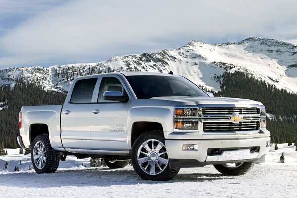 Серебристый Chevrolet Silverado на фоне заснеженных гор