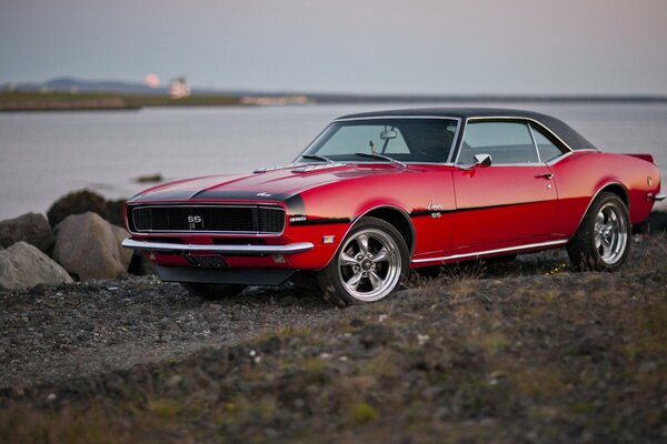 Roter Chevrolet Camaro 1968 auf Flusshintergrund