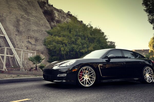 Black Porsche on the background of a beautiful landscape