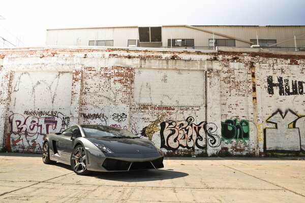 Lamborghini on the background of a brick wall with graffiti