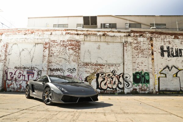 Lamborghini sur fond de mur de briques avec des graffitis