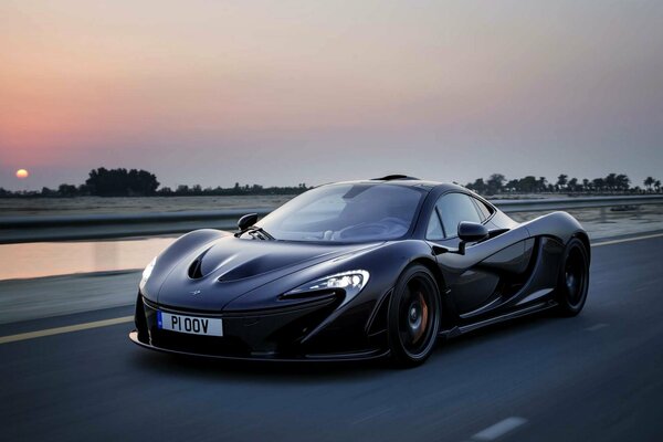 McLaren s schwarzer Supersportwagen vor Sonnenuntergang am Abend