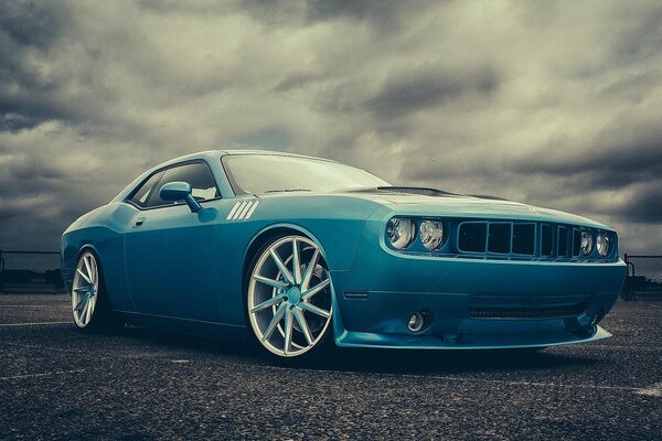 Voiture bleue sous les nuages gris