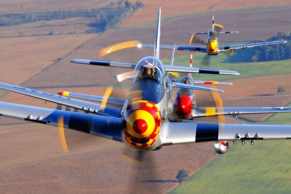 Un grupo de aviones volando sobre el campo