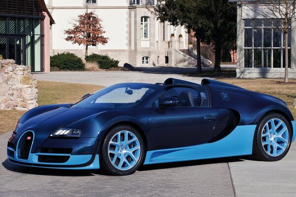 Blue convertible on the background of houses