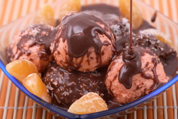 Ice cream balls with liquid chocolate and tangerine slices