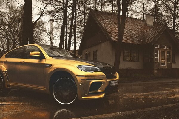 Yellow chrome BMW on the background of the house