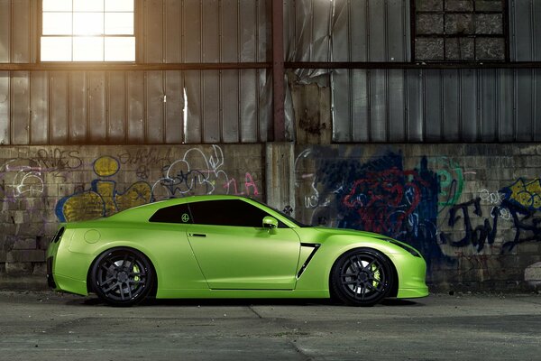 Zielony nissan gt-r w garażu pod oknem