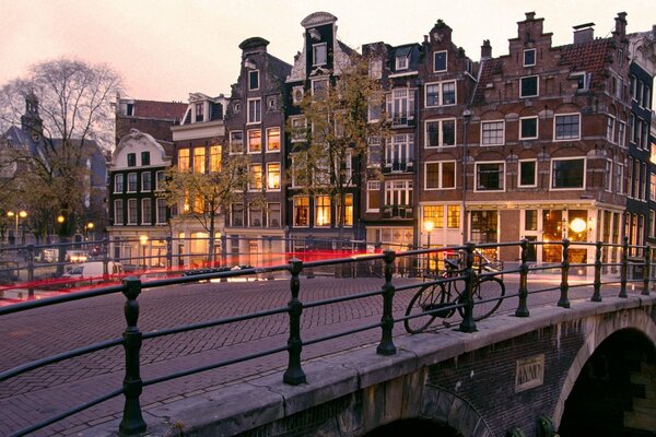 Fahrrad auf einer Brücke in Amsterdam am Abend