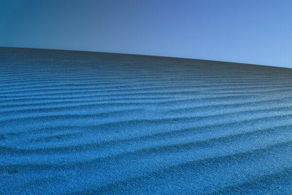 Барханы с синим песком на голубом фоне