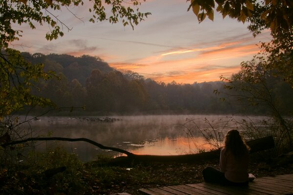 Ragazza solitaria che incontra il crepuscolo sulla riva del Lago