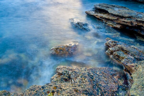 The stone shore by the blue water