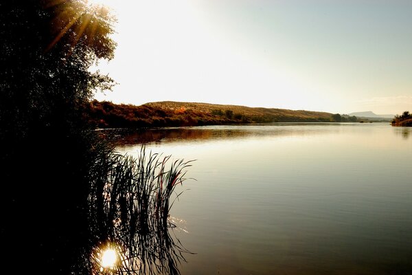 Die Sonnenstrahlen spielen auf dem warmen See