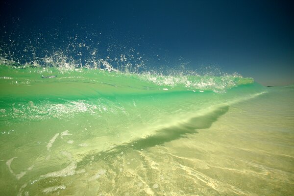 Onde oceaniche color smeraldo che si infrangono sulla riva