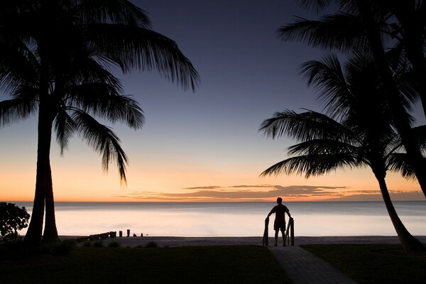 Uomo in riva al mare al tramonto