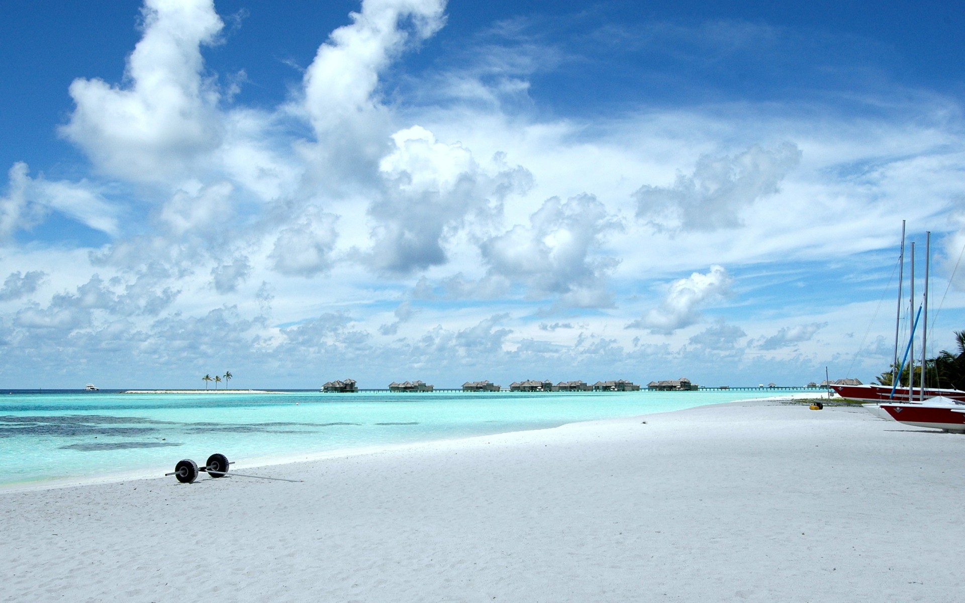 plage sable océan ciel nuages bungalow bateaux