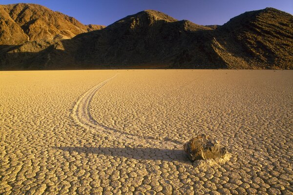 Stein in der Wüste vor dem Hintergrund der Berge