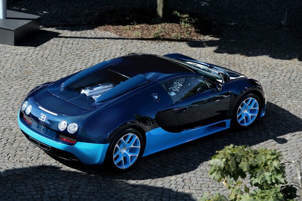 Blue Bugatti in the parking lot of paving stones