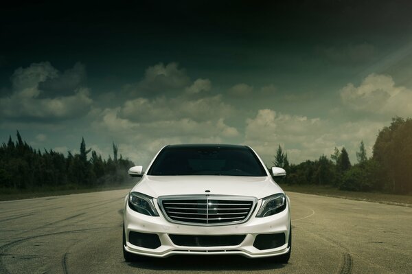 White Mercedes Benz car on the sky background