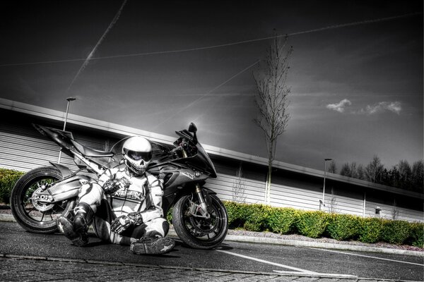 BMW sport bike with a motorcyclist sitting next to it