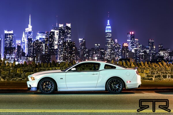 Ford Mustang sur le fond de la ville de nuit