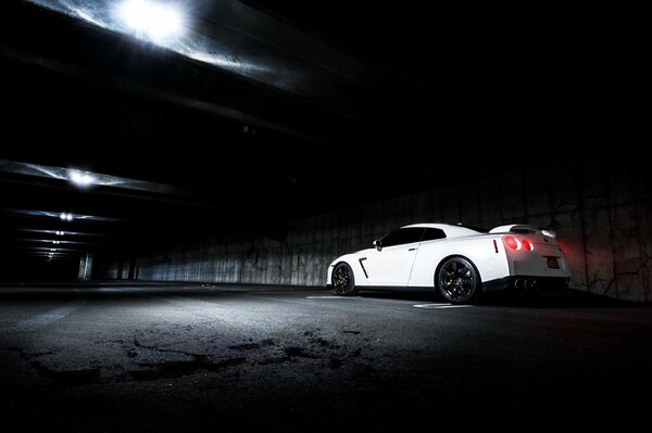 W ciemności po drodze jedzie biały Nissan
