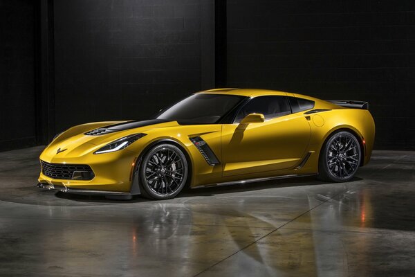 Chevrolet corvette Z06 amarillo contra una pared negra