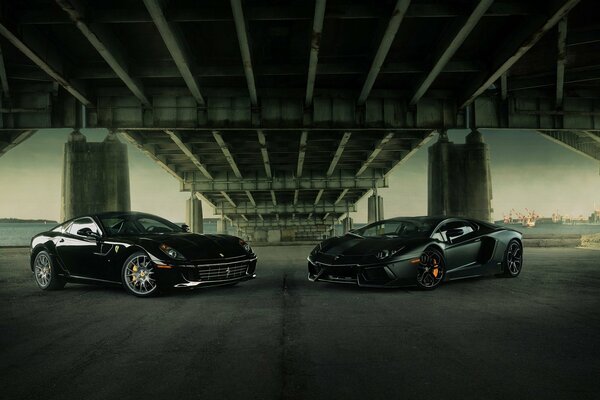 Dos superdeportivos Lamborghini y Ferrari se reúnen bajo un puente en la ciudad