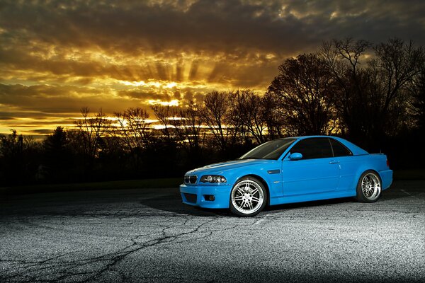 Blauer BMW auf Sonnenuntergang Hintergrund