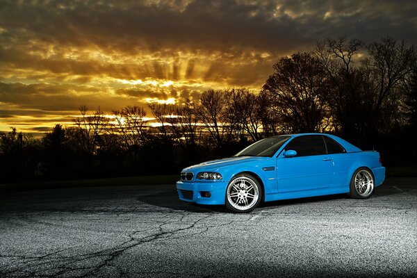 Blue BMW on the background of sunset