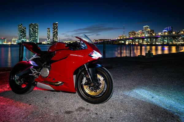 Czerwony motocykl na tle nocnego miasta