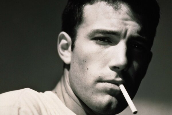 Schwarz-Weiß-Foto von Schauspieler Ben Affleck mit einer Zigarette in den Zähnen