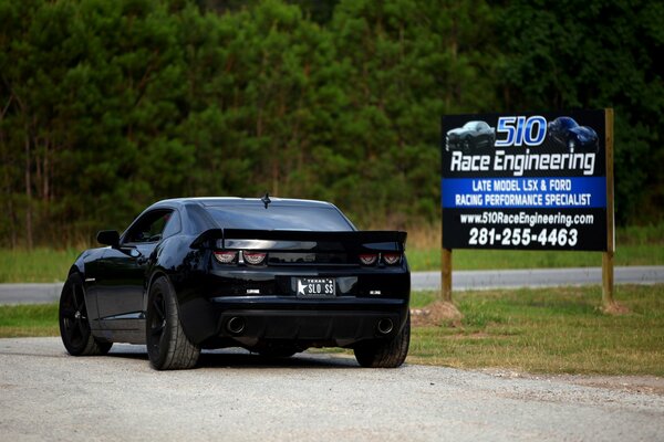 Schwarzer getunter Chevrolet mit Plakatwand