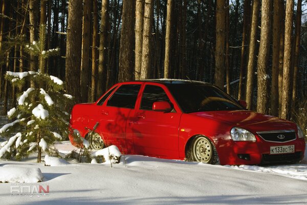 Voiture du Prieuré rouge sur fond neigeux